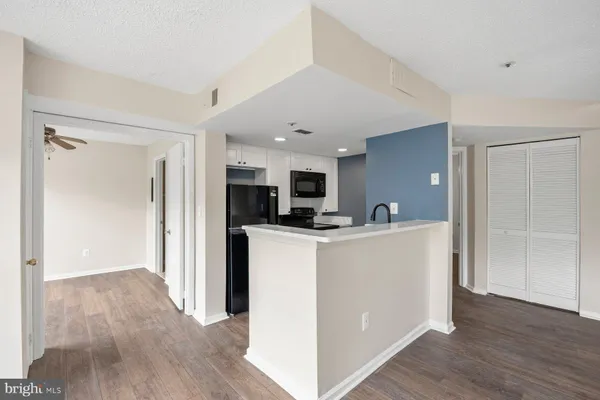 a view of kitchen with stainless steel appliances granite countertop a refrigerator and a stove top oven