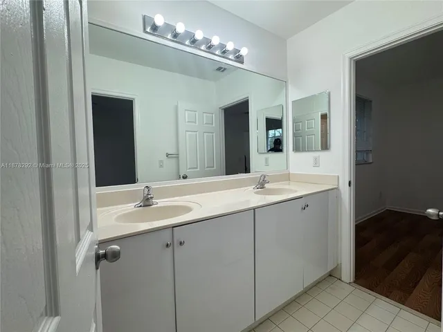 a bathroom with a double vanity sink and a mirror