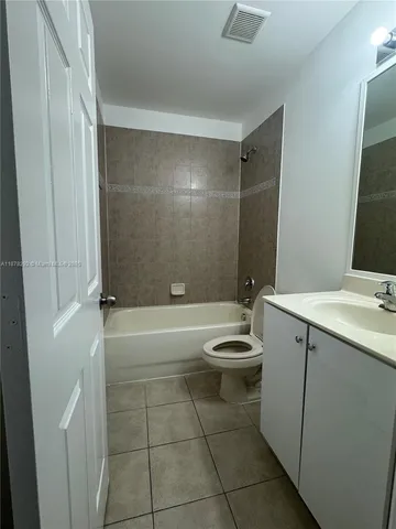 a bathroom with a bathtub shower sink vanity and toilet