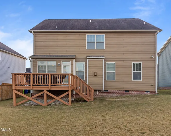 a view of a house with wooden deck and furniture
