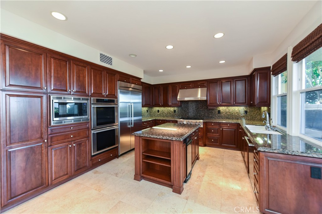 21 Marisol Newport Coast, CA 92657 - Photo 10 of 35 a kitchen with wooden cabinets and stainless steel appliances