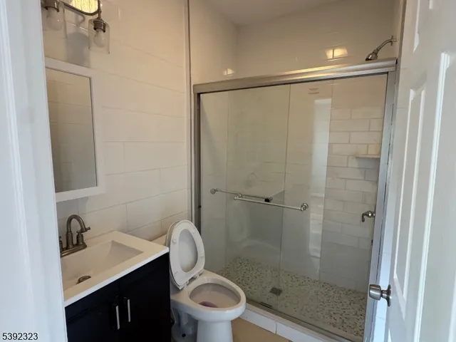 a bathroom with a granite countertop sink toilet and shower