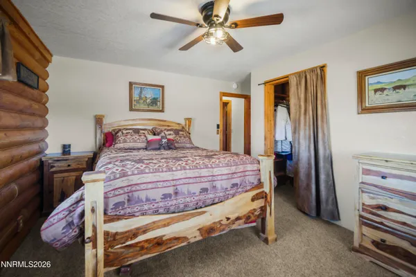 a bedroom with a bed and a flat tv screen on dresser
