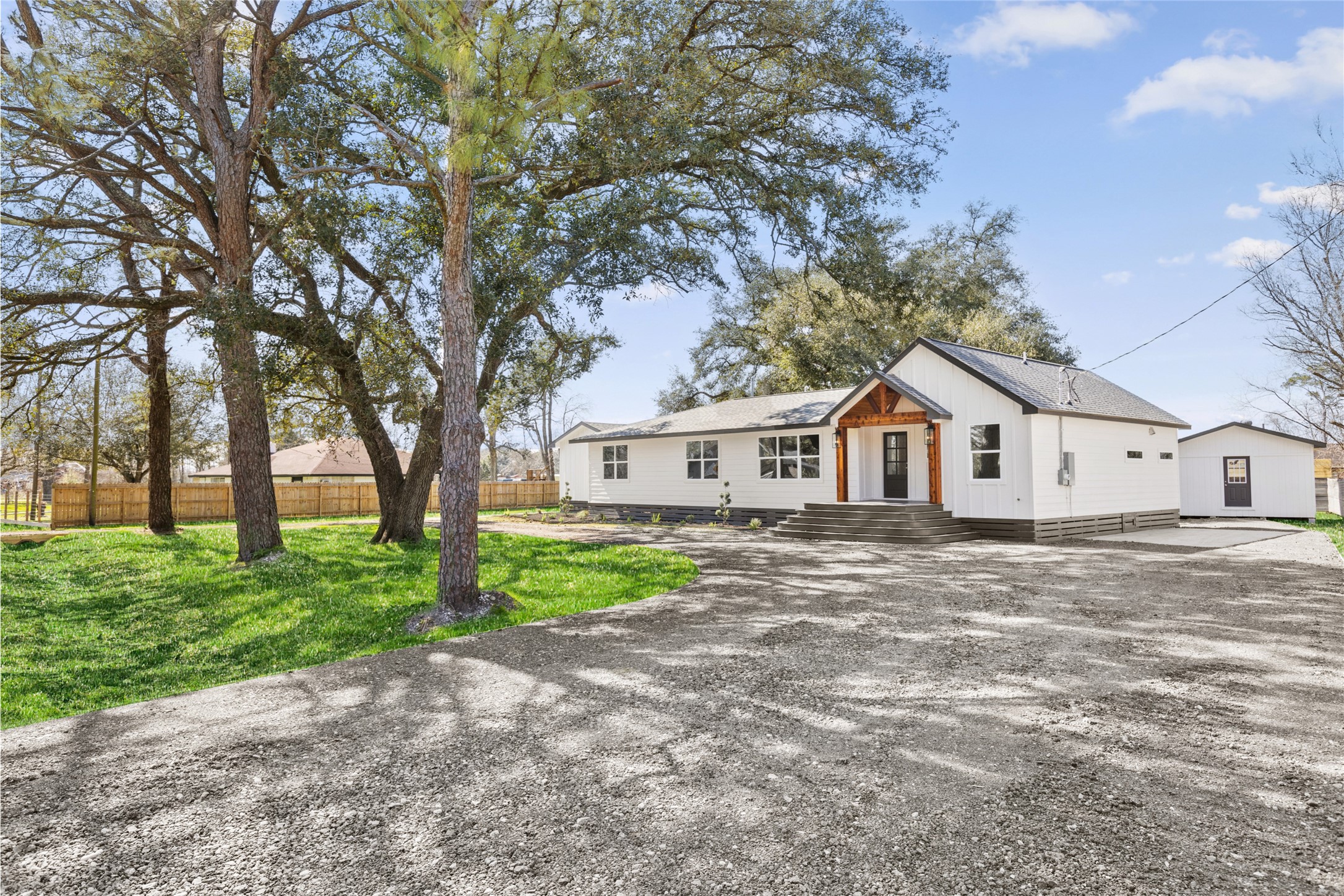 a view of a yard in front of a house with large trees