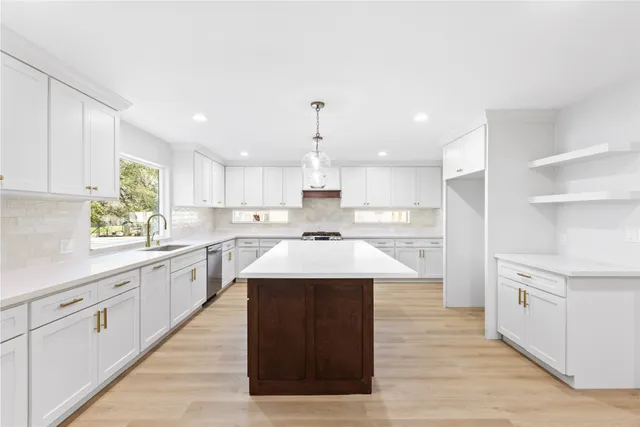 a large kitchen with a stove top oven and cabinets