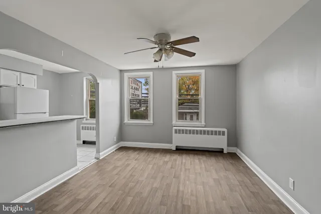 a view of a kitchen with wooden floor and stainless steel appliances