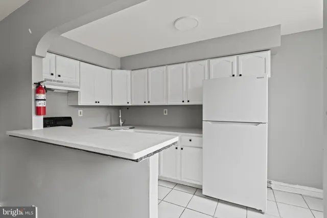 a kitchen with white cabinets and appliances