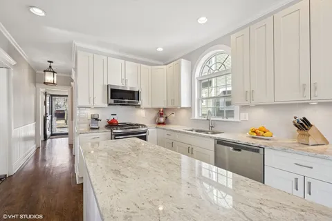 a large living room with stainless steel appliances granite countertop furniture a fireplace a flat screen tv and a large window