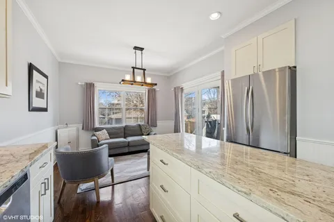 a living room with stainless steel appliances furniture and a kitchen view