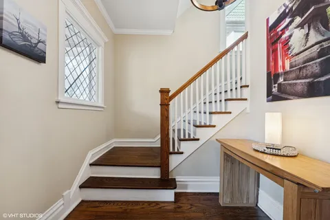 a view of a hallway with wooden floor and a bathroom