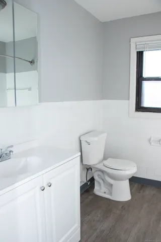 a bathroom with a toilet a sink and a window