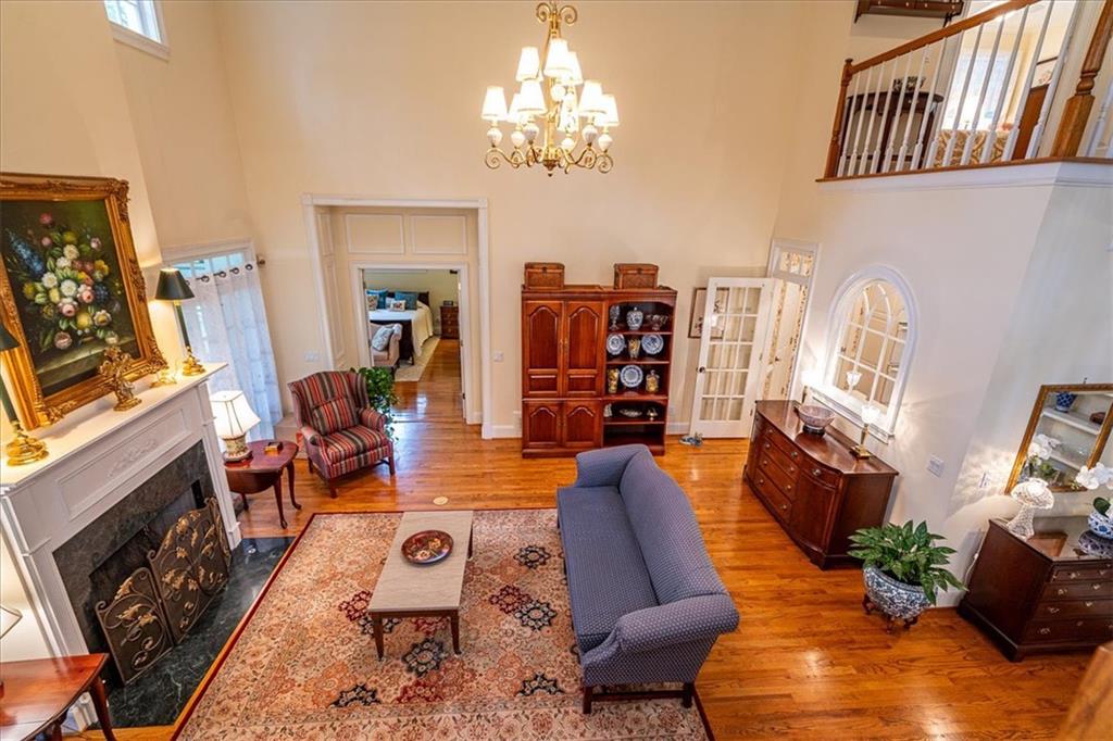 416 McDaniel Street Monroe, GA 30655 - Photo 30 of 69 a living room with furniture a fireplace and a chandelier