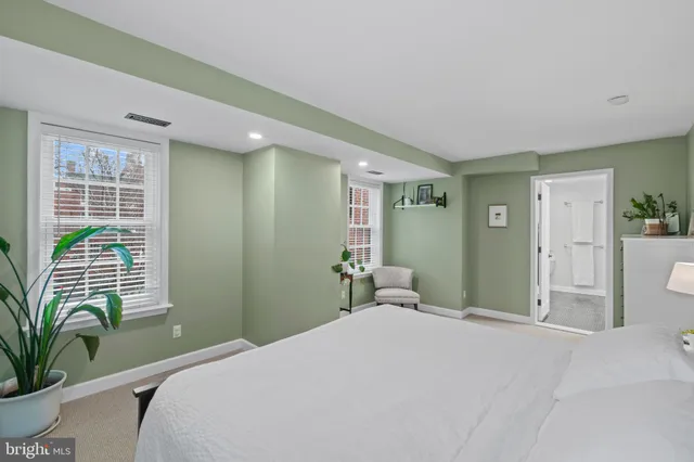 a bedroom with a large bed and a potted plant