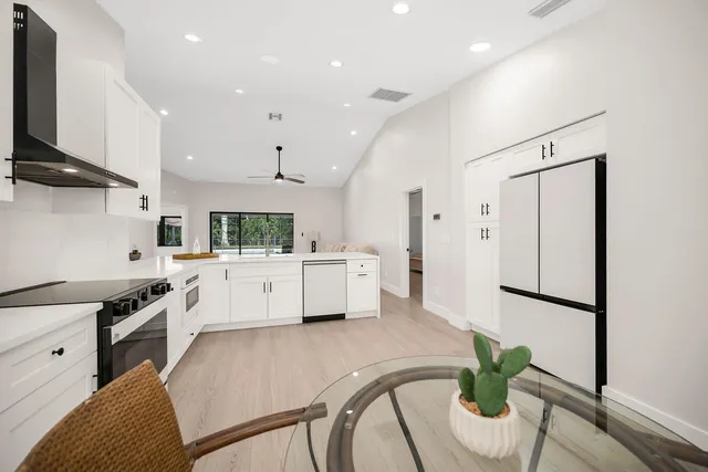 a kitchen with stainless steel appliances kitchen island granite countertop a stove a sink and a refrigerator