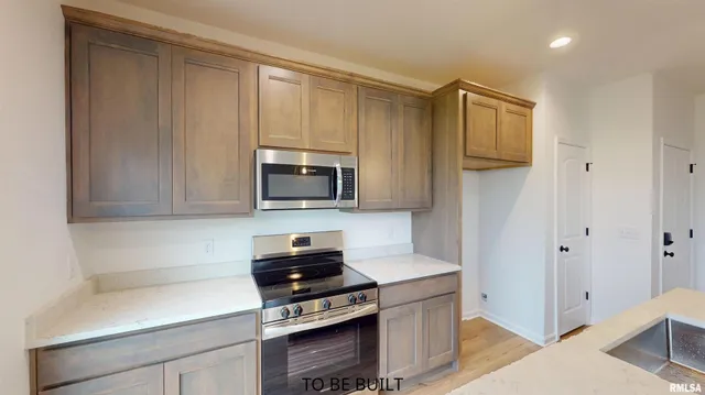 a kitchen with stainless steel appliances a stove a microwave and cabinets
