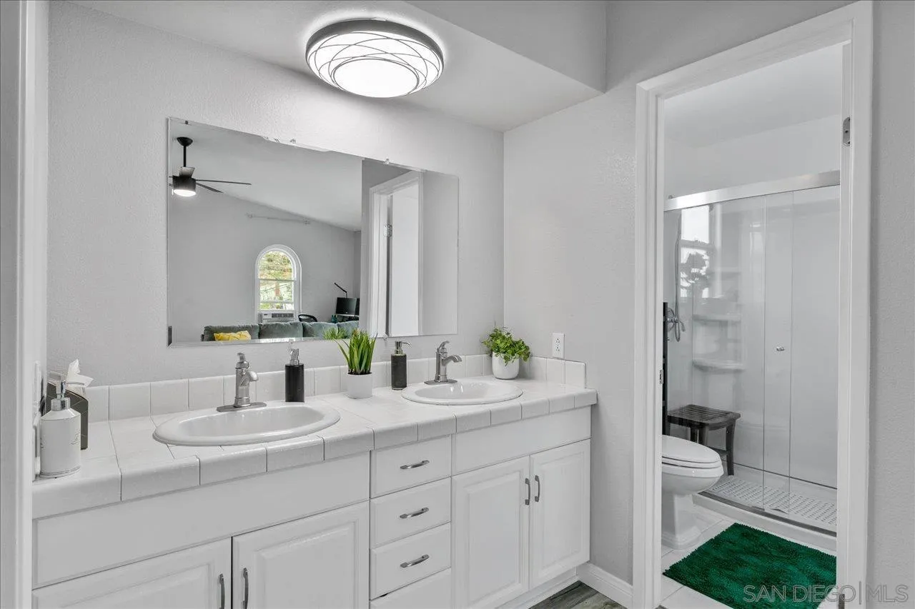 13663 Paseo Del Mar El Cajon, CA 92021 - Photo 24 of 36 a bathroom with a toilet a sink and mirror