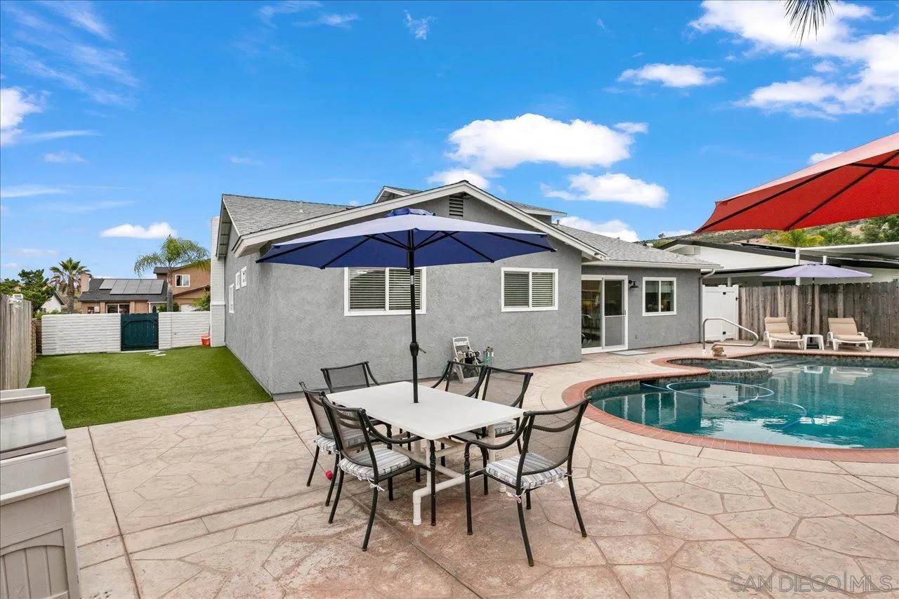 13663 Paseo Del Mar El Cajon, CA 92021 - Photo 32 of 36 a patio with a table and chairs under an umbrella