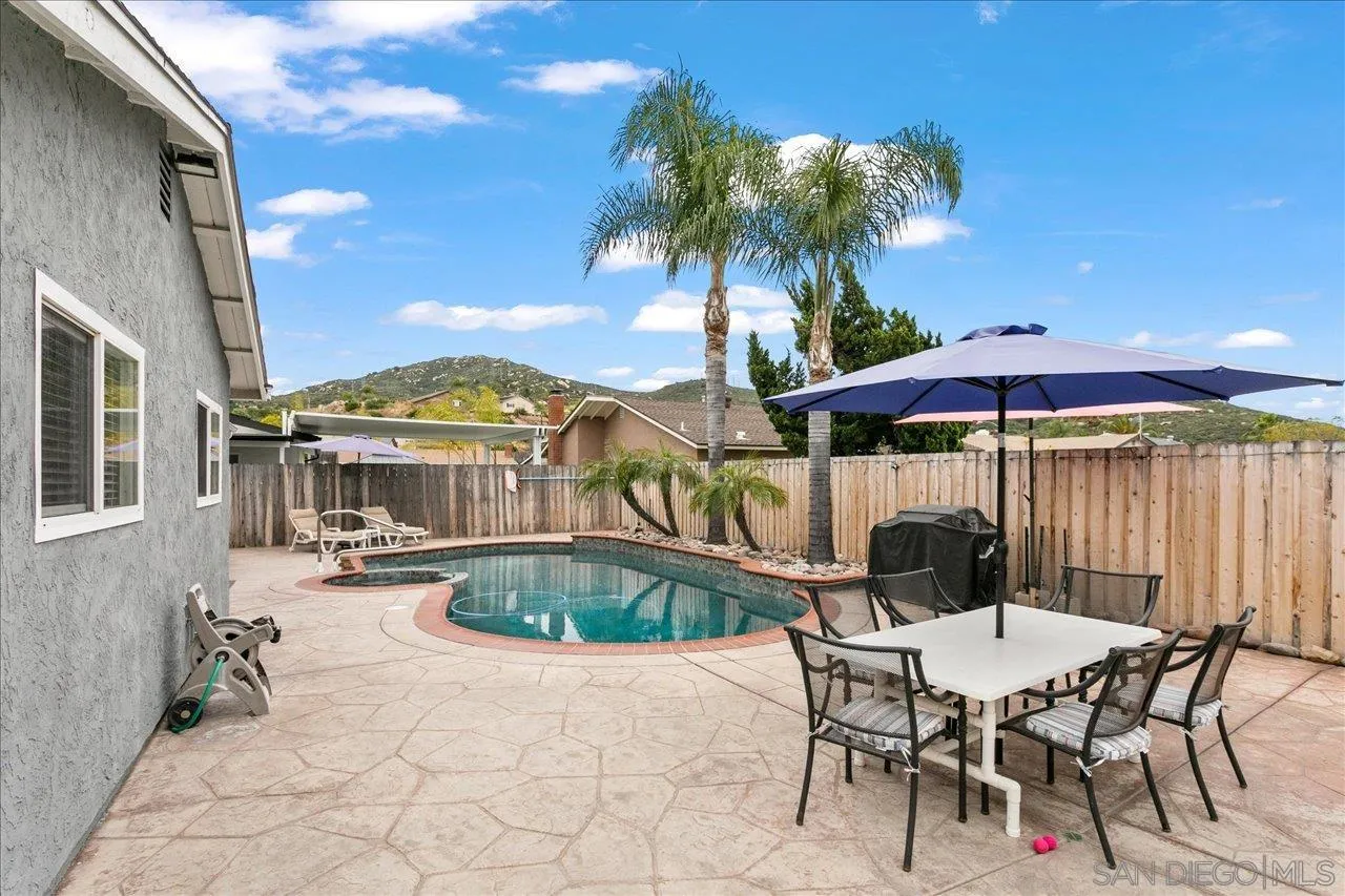 13663 Paseo Del Mar El Cajon, CA 92021 - Photo 35 of 36 a patio with a table and chairs under an umbrella