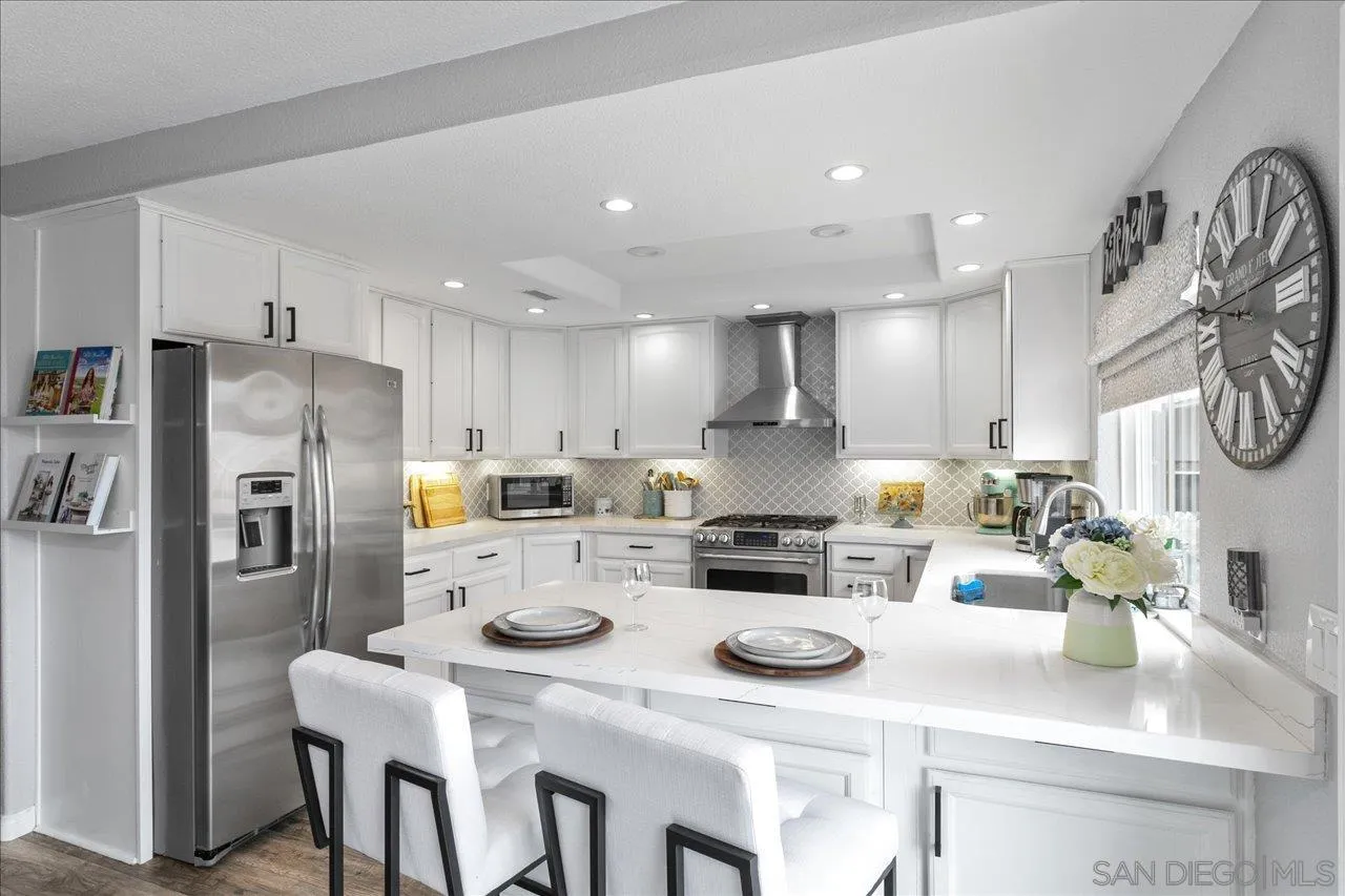 13663 Paseo Del Mar El Cajon, CA 92021 - Photo 10 of 36 a kitchen with refrigerator a stove a dining table and chairs