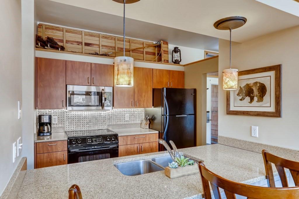 2017 Soda Ridge Road, Unit 1938 Keystone, CO 80435 - Photo 9 of 31 a kitchen with stainless steel appliances granite countertop a refrigerator a stove a sink a dining table and chairs with wooden floor