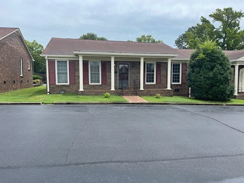 a front view of a house with a yard and porch