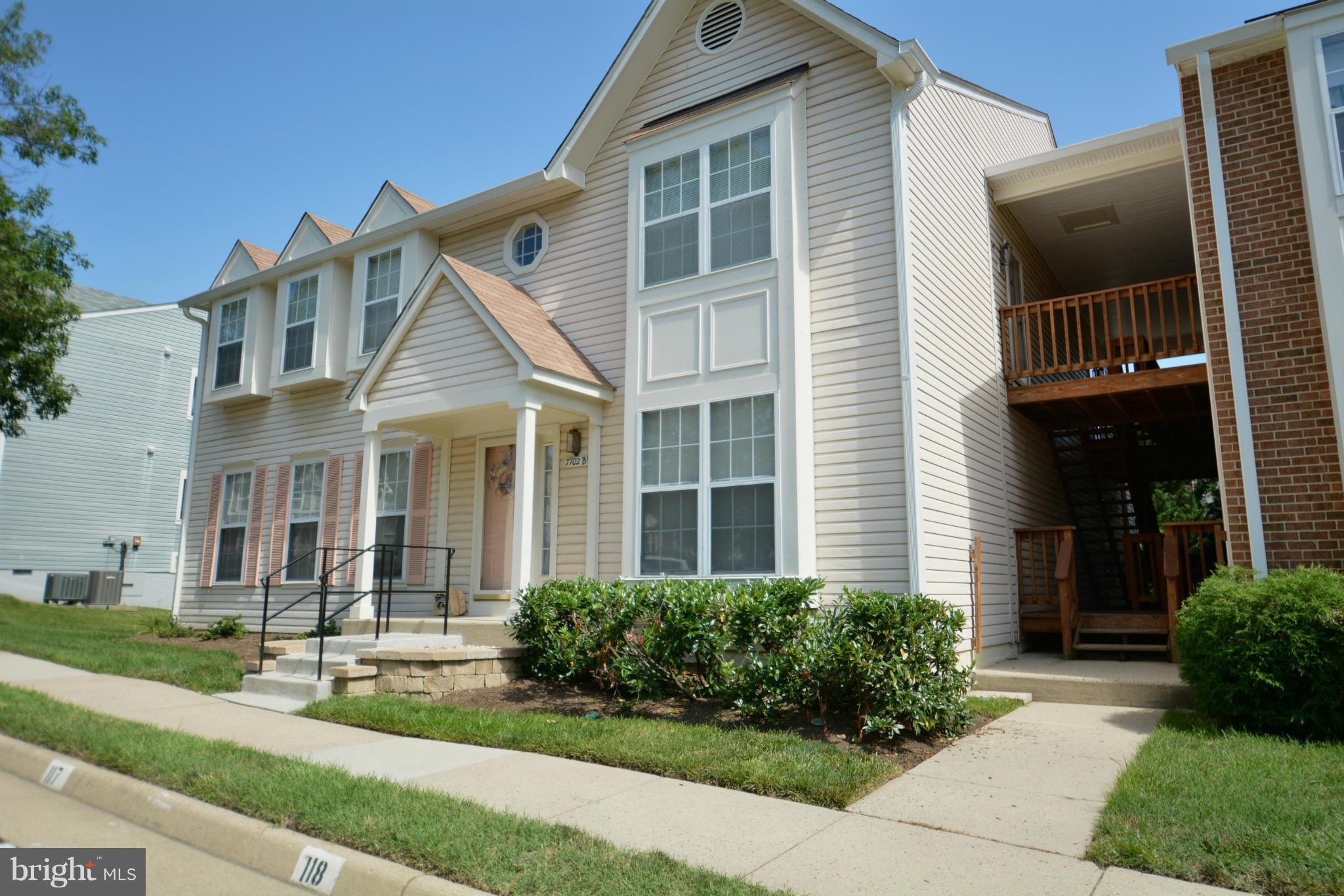 7702 Lexton Place, Unit A Springfield, VA 22152 - Photo 1 of 22 a front view of a house with garden and porch