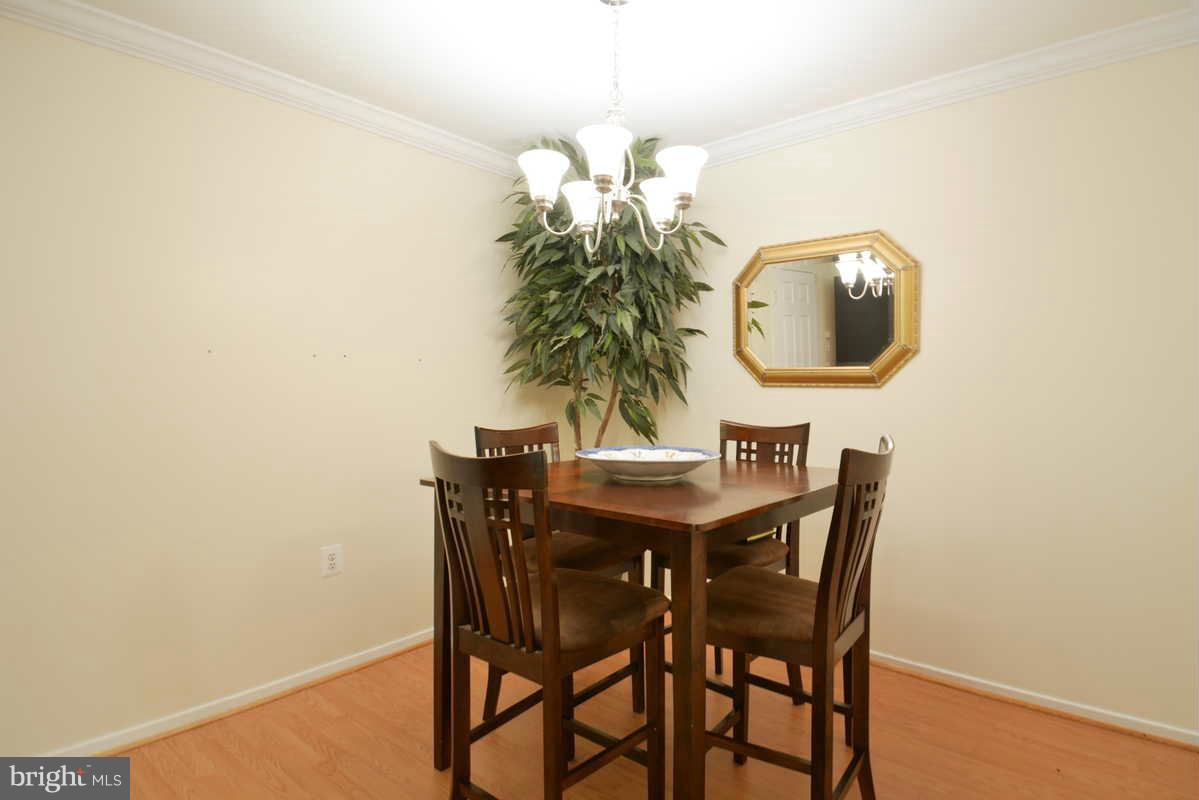 7702 Lexton Place, Unit A Springfield, VA 22152 - Photo 4 of 22 a view of a dining room with furniture and wooden floor