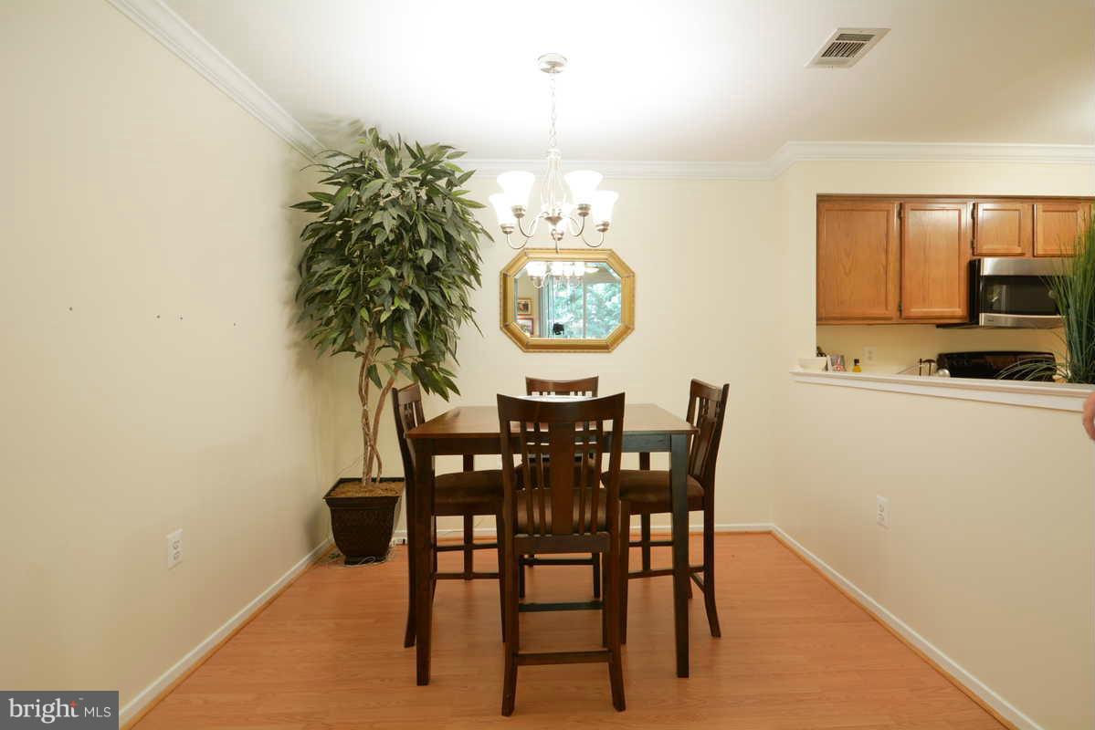 7702 Lexton Place, Unit A Springfield, VA 22152 - Photo 5 of 22 a view of a dining room with furniture and chandelier
