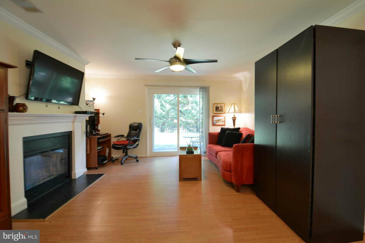 7702 Lexton Place, Unit A Springfield, VA 22152 - Photo 9 of 22 a living room with furniture a flat screen tv and a fireplace