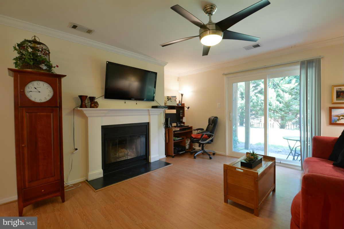 7702 Lexton Place, Unit A Springfield, VA 22152 - Photo 10 of 22 a living room with furniture a flat screen tv and a fireplace