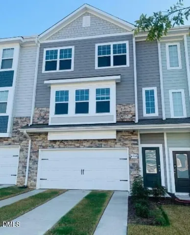 a large brick building with a small yard and large trees