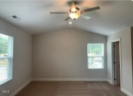 an empty room with windows and fan