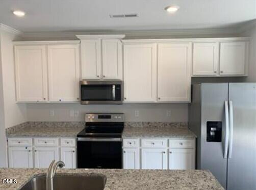 6927 Eddy Point Lane Raleigh, NC 27616 - Photo 2 of 27 a kitchen with granite countertop white cabinets and stainless steel appliances