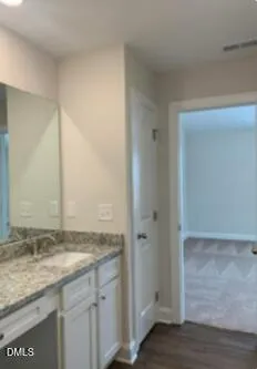 a bathroom with a granite countertop sink and a mirror