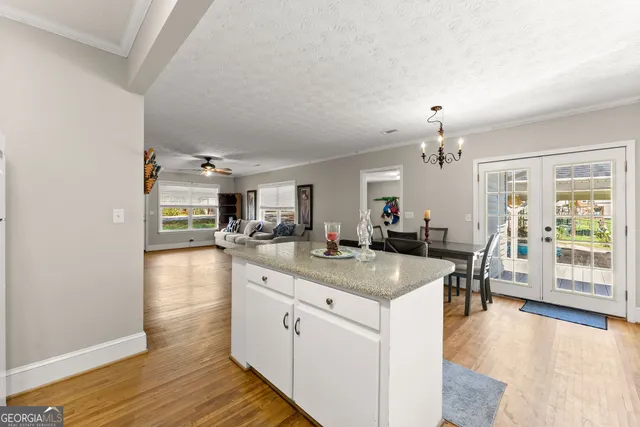 a kitchen with granite countertop white cabinets white appliances a sink and a window