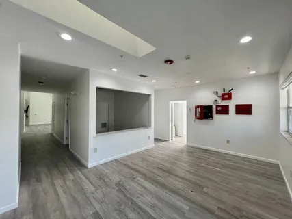 a view of a livingroom with a computer on the floor and wooden floor