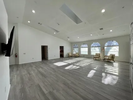 a bedroom with a bed and large windows