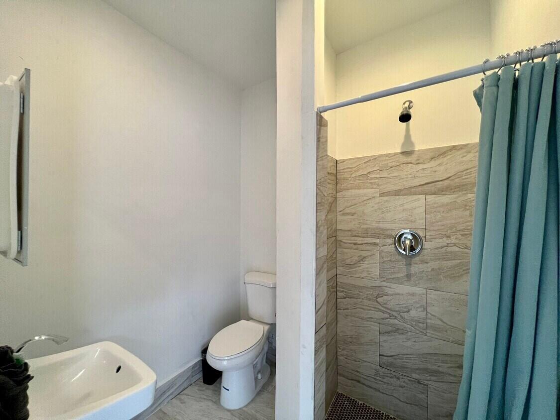 1020 North Riverside Drive Pompano Beach, FL 33062 - Photo 16 of 32 a bathroom with a shower a toilet and sink