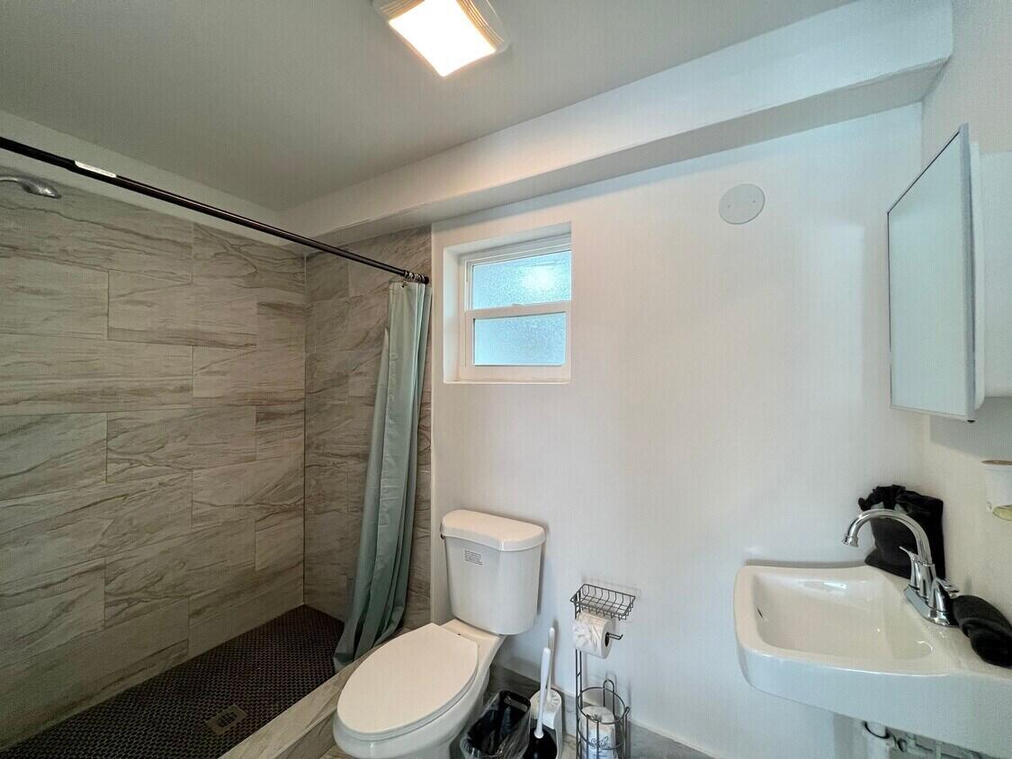 1020 North Riverside Drive Pompano Beach, FL 33062 - Photo 18 of 32 a bathroom with a sink a toilet and shower