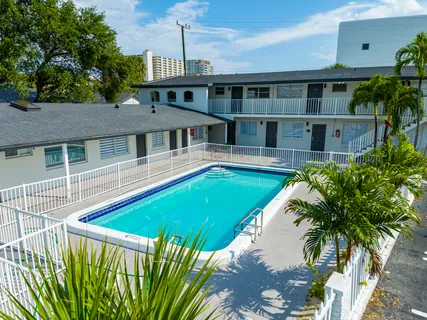 a view of a house with pool and chairs