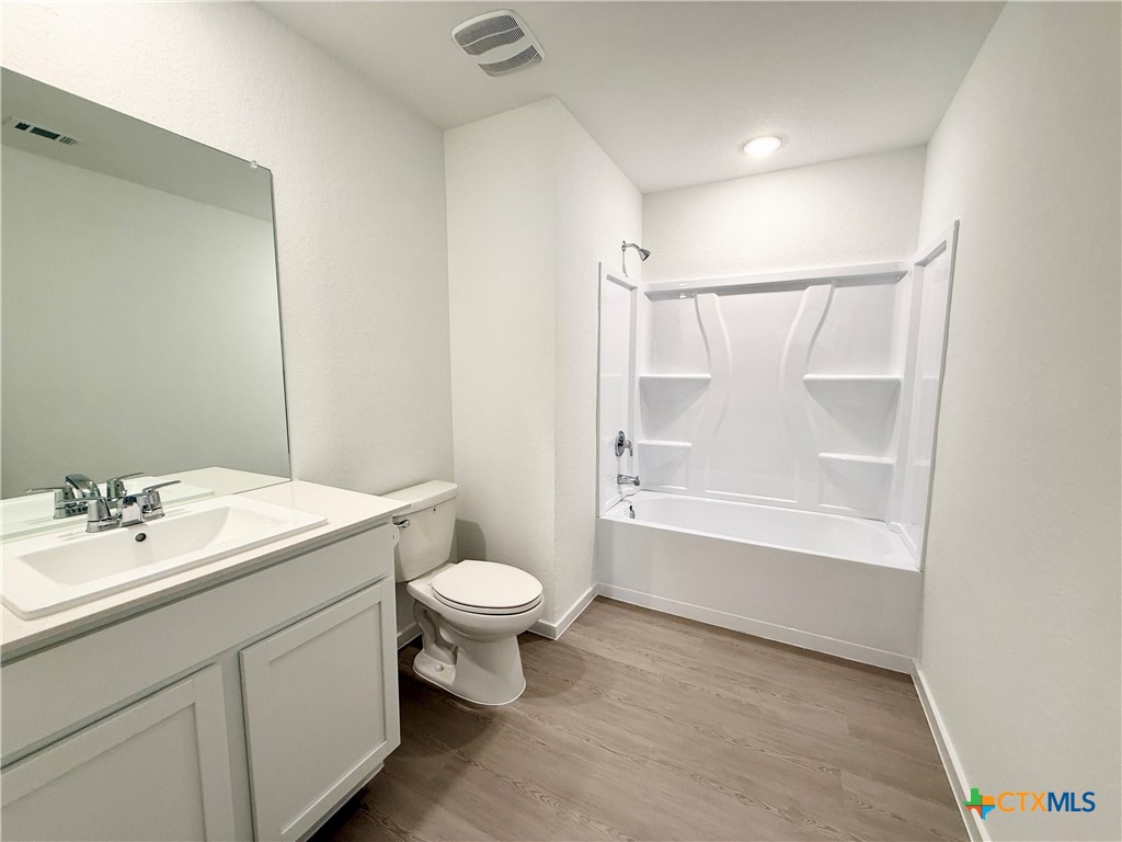 311 Moscato Road New Braunfels, TX 78130 - Photo 22 of 38 a bathroom with a sink toilet a mirror and shower
