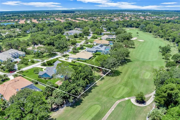 an aerial view of residential houses with outdoor space and trees