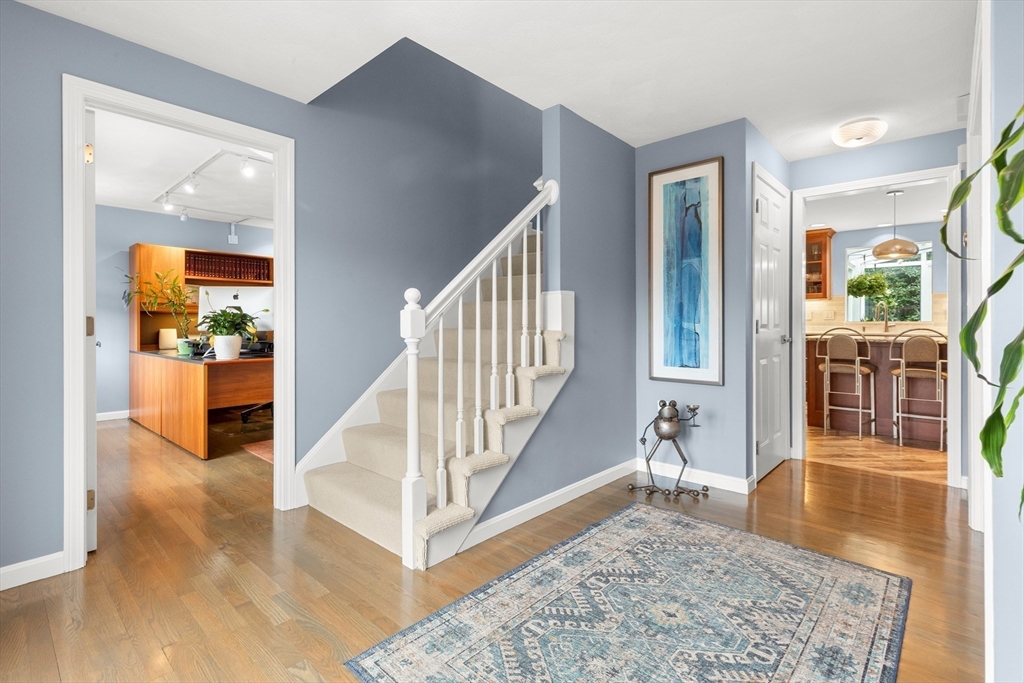 7 Derosier Drive Middleton, MA 01949 - Photo 18 of 42 a view of a hallway with wooden floor and a living room