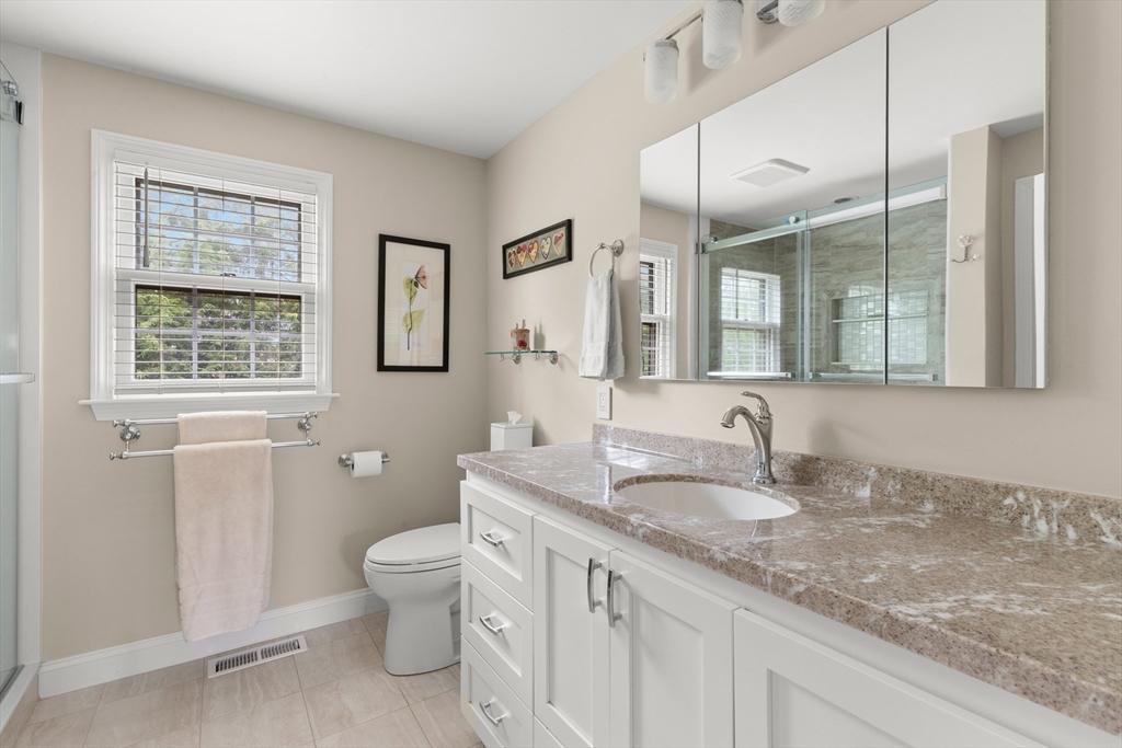 7 Derosier Drive Middleton, MA 01949 - Photo 25 of 42 a bathroom with a granite countertop double vanity sink a mirror and a toilet