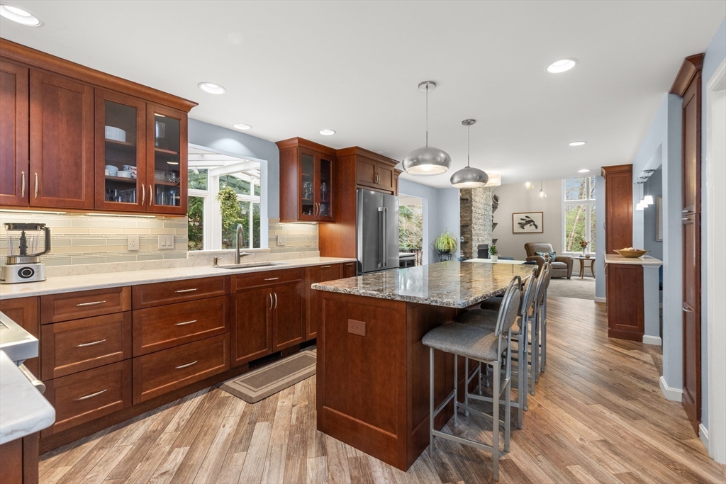 7 Derosier Drive Middleton, MA 01949 - Photo 8 of 42 a kitchen with granite countertop a table chairs stove and cabinets
