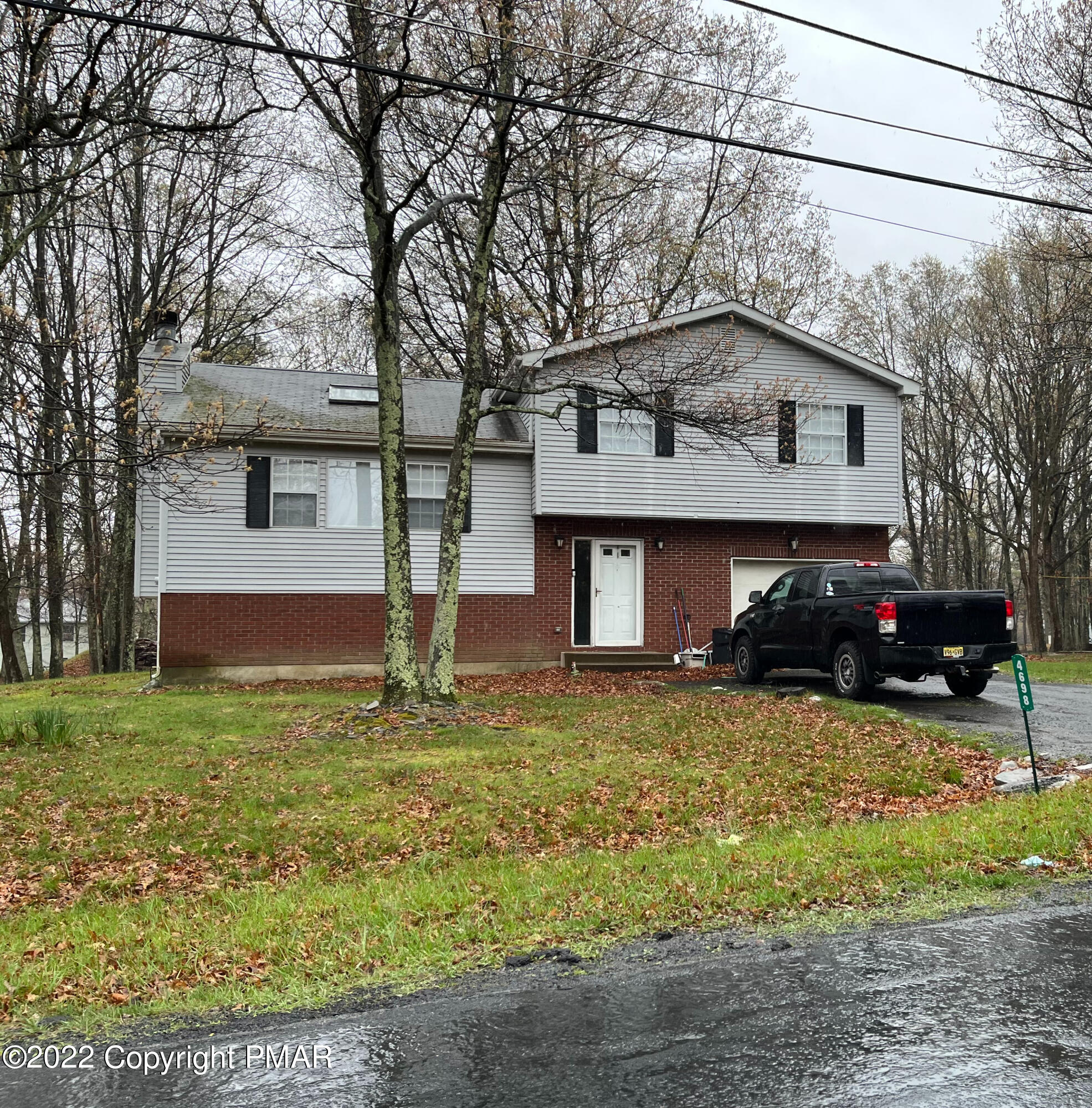4698 Pine Ridge Drive West Bushkill, PA 18324 - Photo 1 of 17 a front view of house with yard and trees in the background