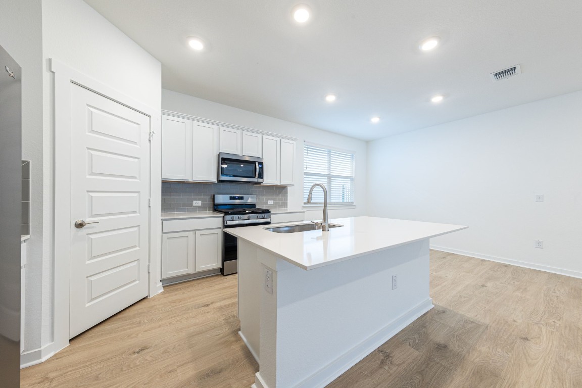 a kitchen with a sink a stove top oven and white kitchen
