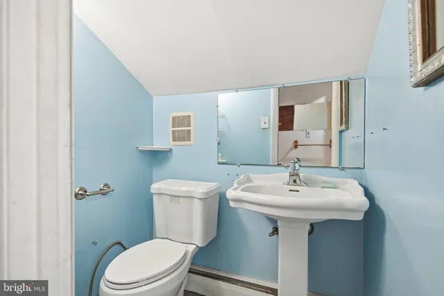 a bathroom with a sink toilet and mirror