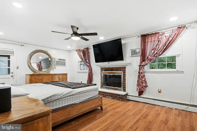 a bedroom with a bed a flat screen tv and a fireplace