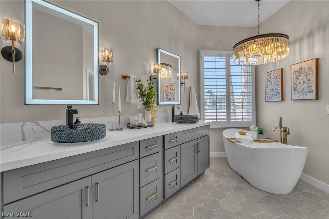 8848 Rainbow Ridge Drive Las Vegas, NV 89117 - Photo 33 of 43 Luxurious bathroom with dual vanities, modern fixtures, and an elegant freestanding tub.